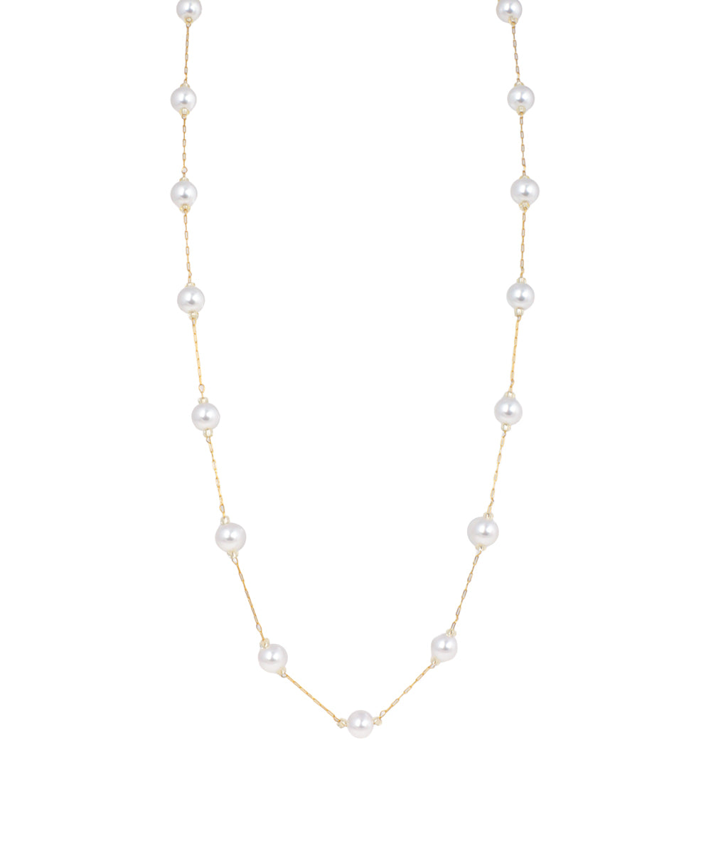 Gold-tone necklace with spaced white faux pearls on a delicate chain