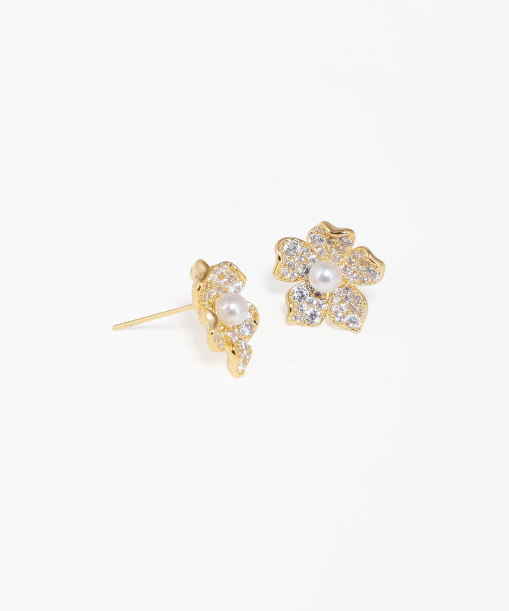 Gold floral stud earrings featuring a central pearl accent