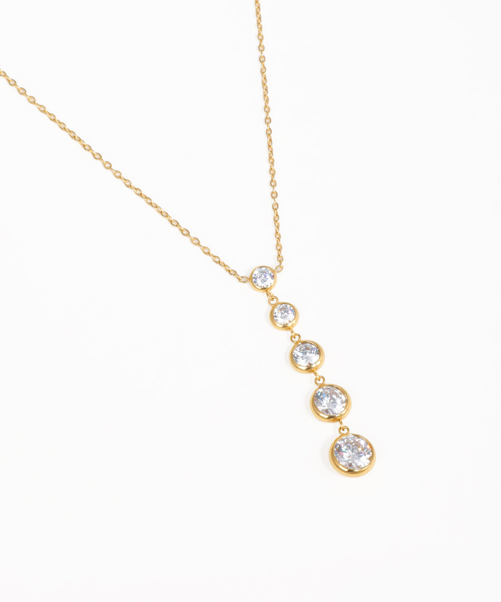 Sleek minimalist stone drop necklace with graduated crystal pendants and gold-tone chain