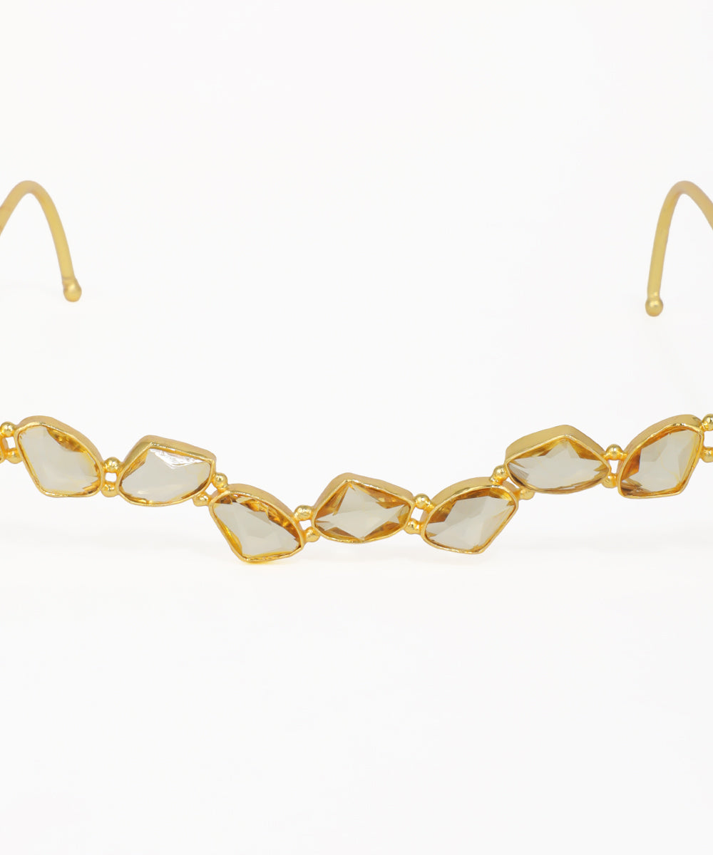 Stylish gold facelet featuring faceted geometric stones along a curved design