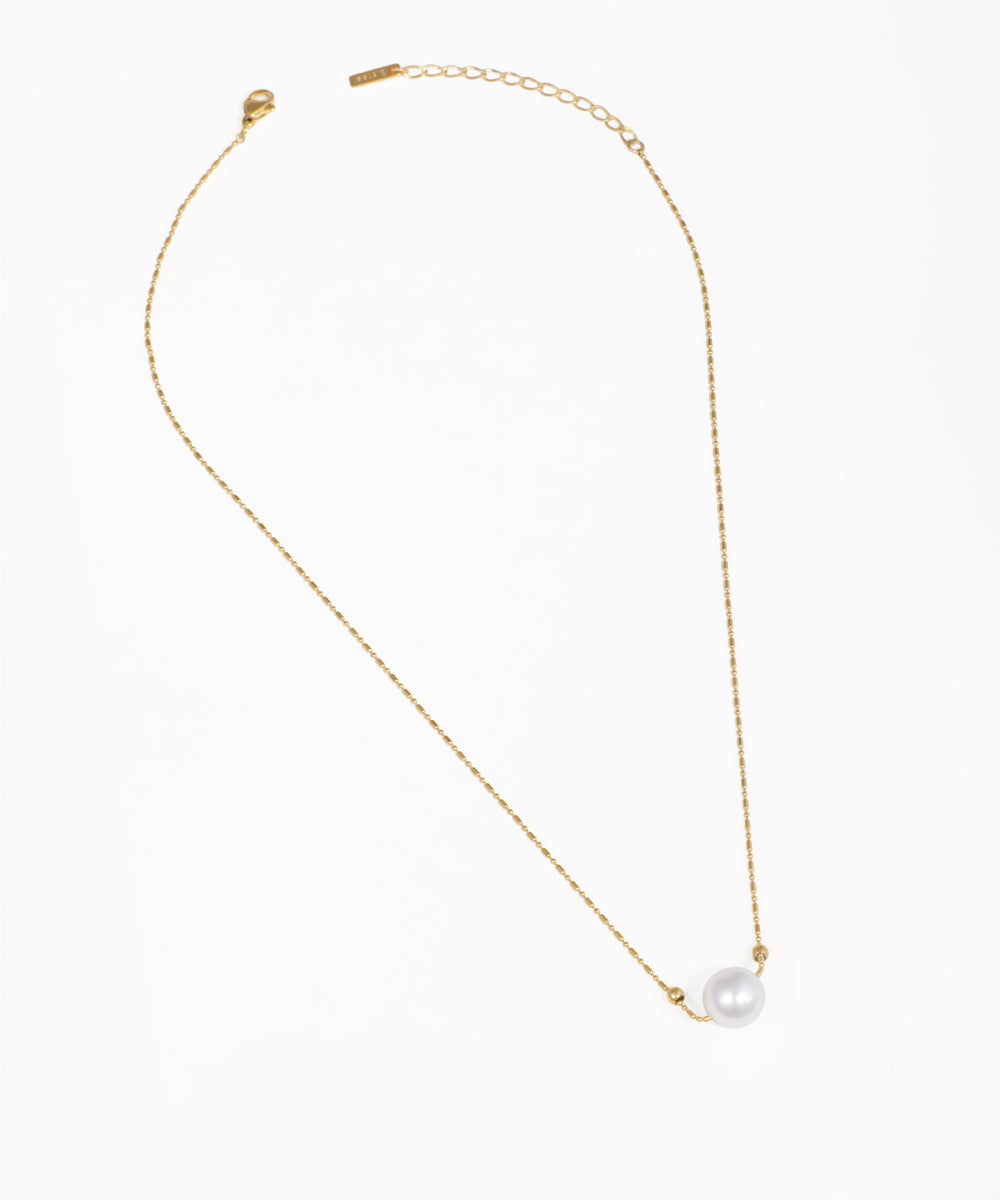 Gold-tone necklace with a delicate chain and a single faux pearl bead