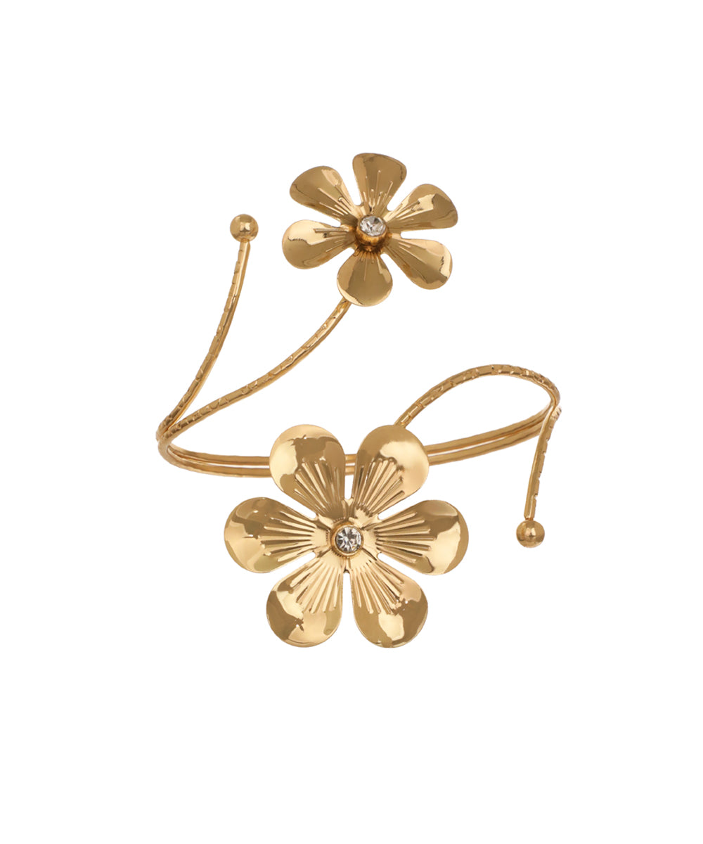 Gold-tone arm cuff with two sculpted floral designs, each featuring a small clear stone center, on a winding textured band.