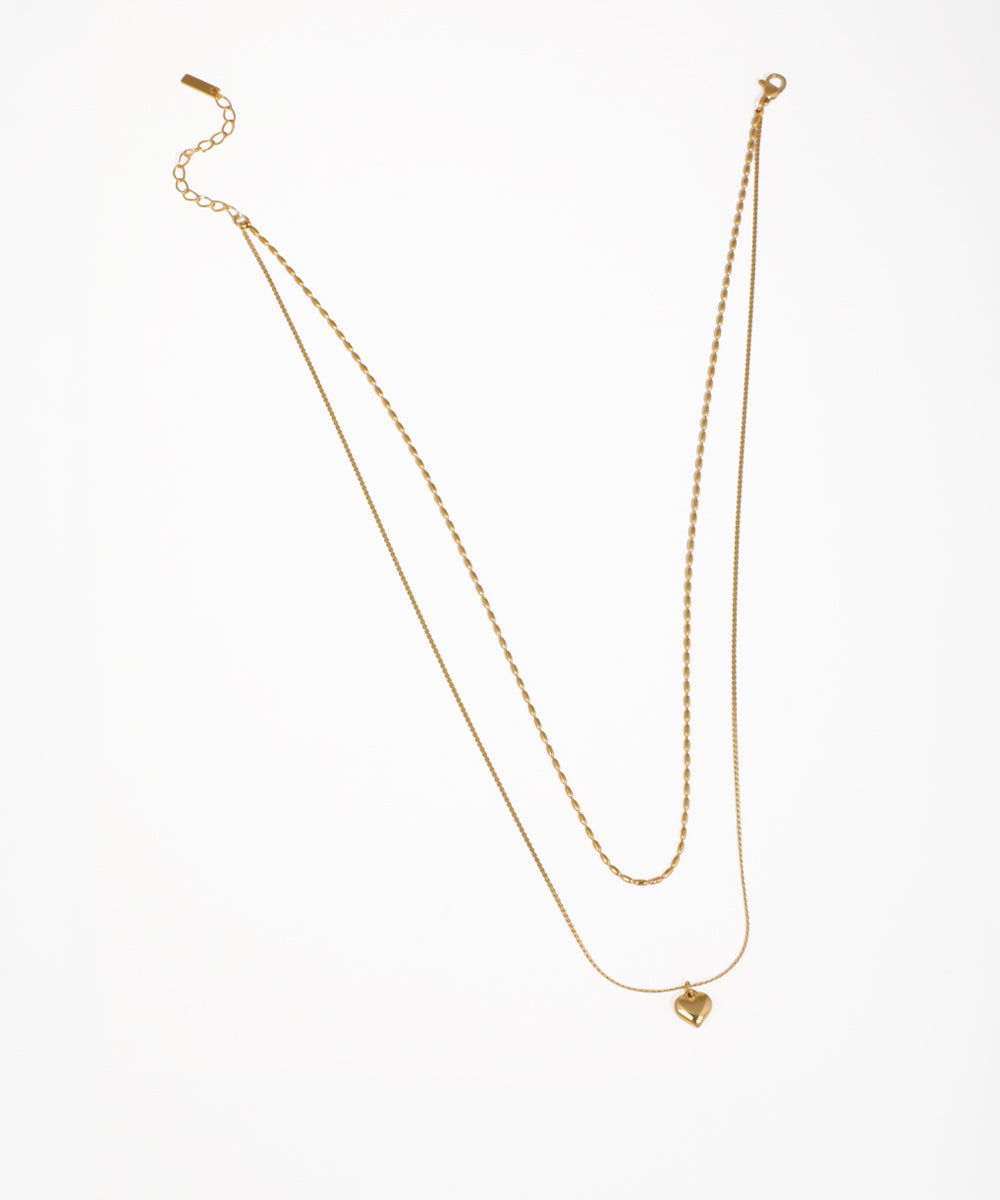 Gold-tone layered necklace with two delicate chains and a small heart pendant