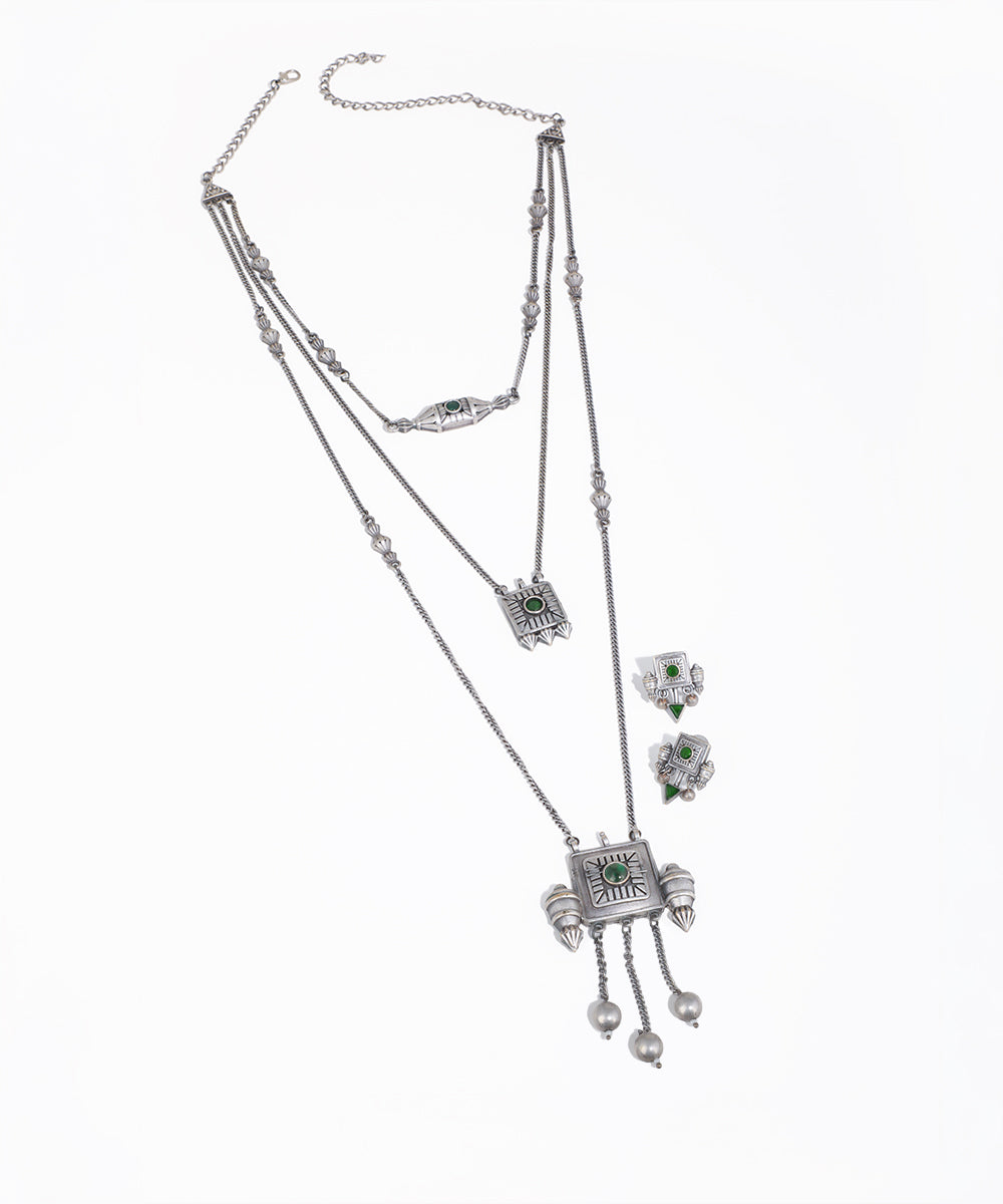 Silver necklace and earrings set on a white background