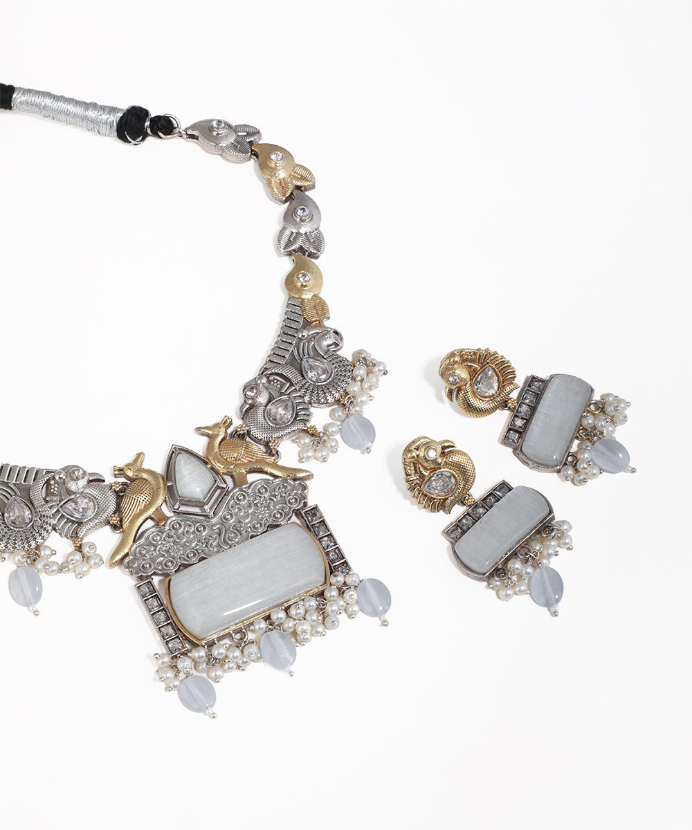 Ornate necklace and earrings set on a white background