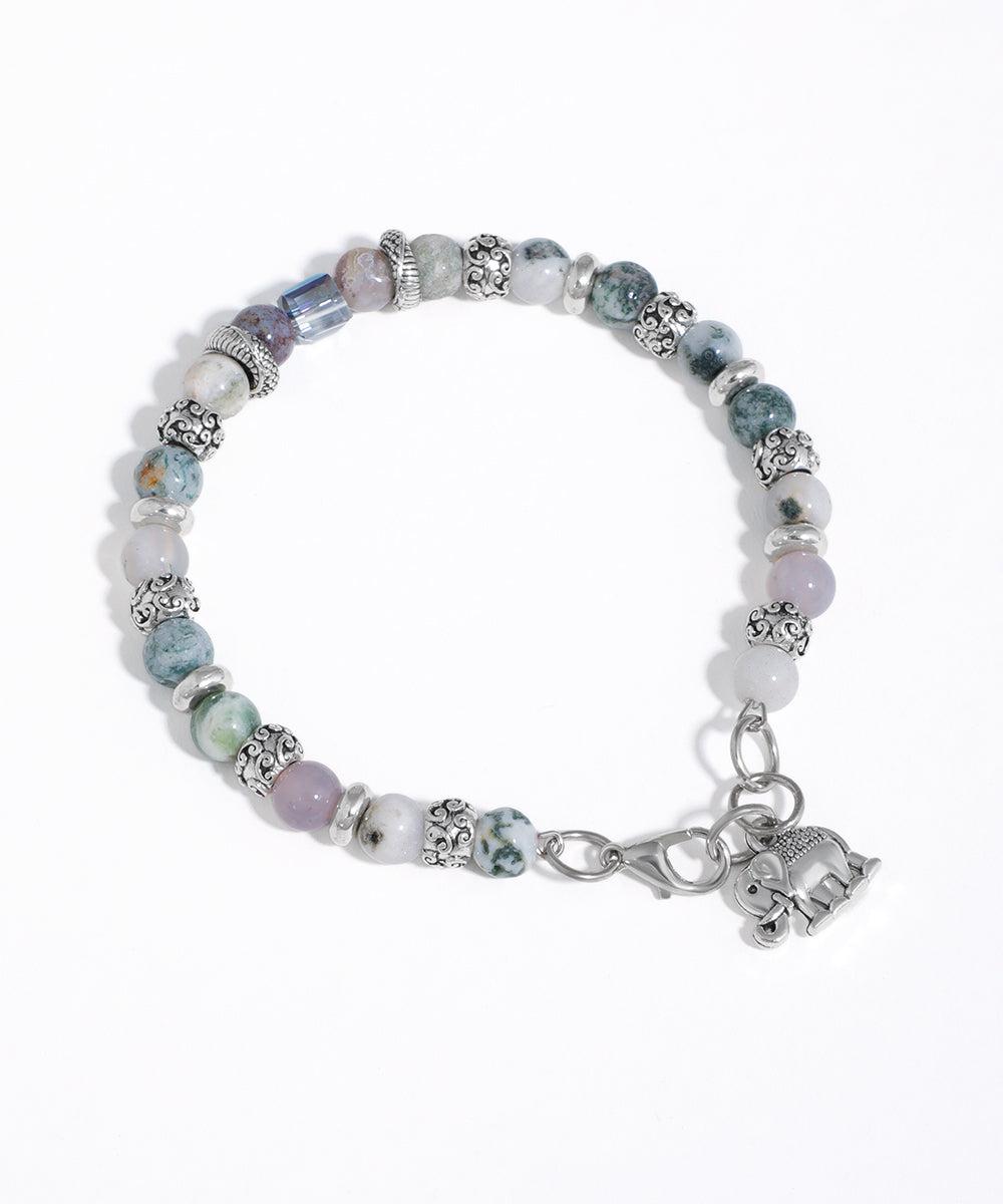 Silver-tone beaded bracelet with mixed stone beads, one blue faceted glass crystal, and an elephant charm.
