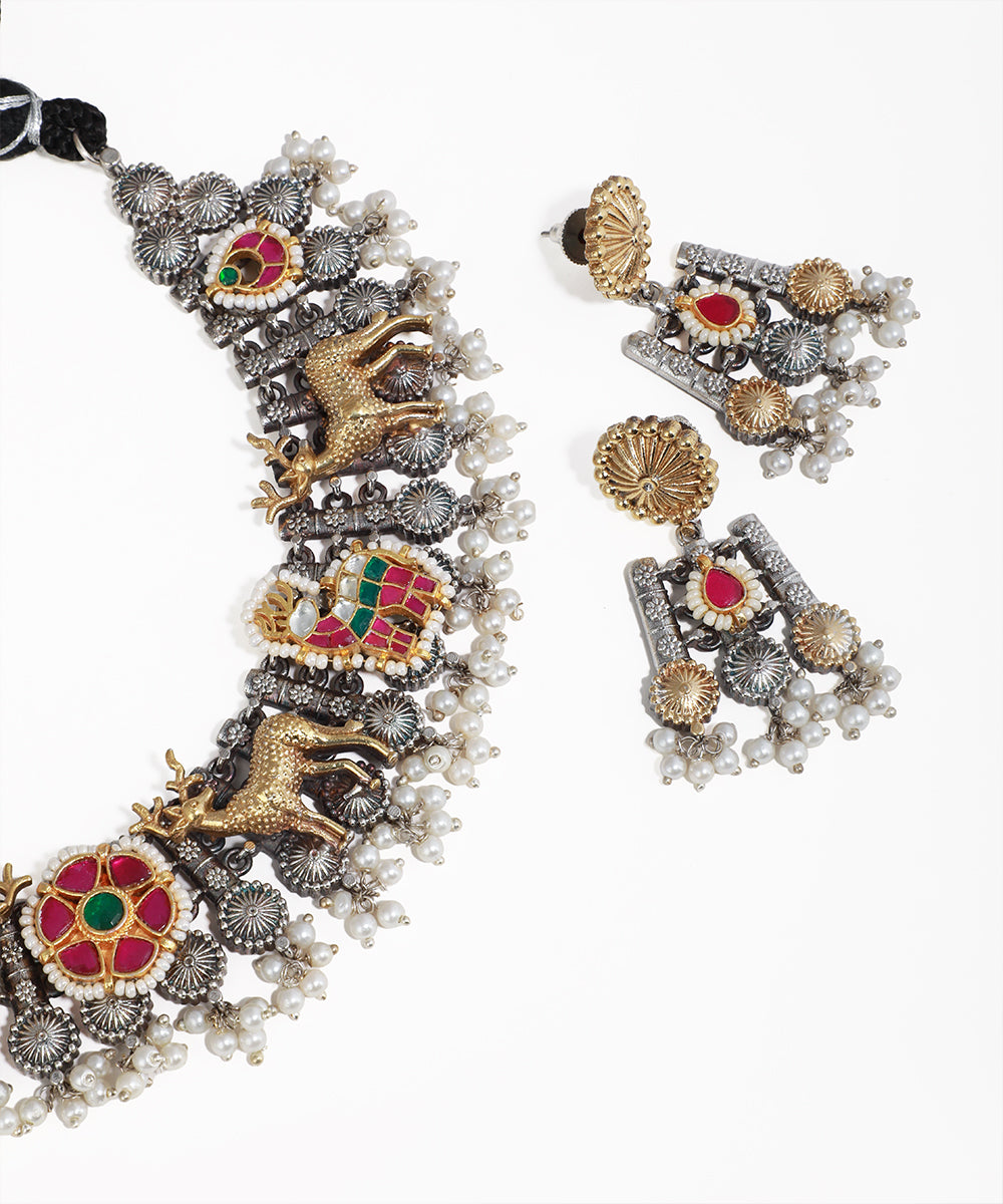 Ornate necklace and earrings with intricate designs on a white background