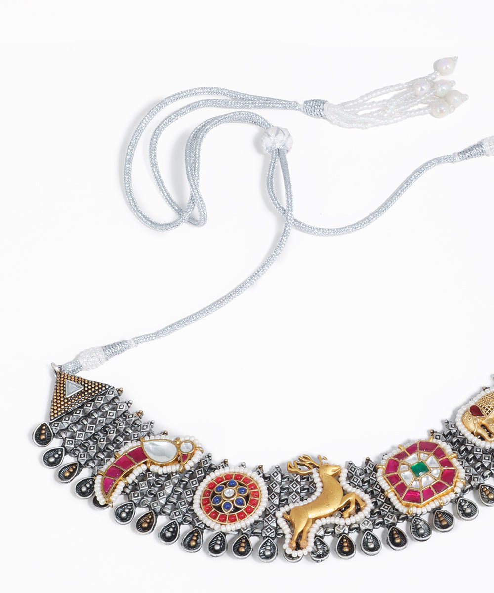 Decorative necklace with intricate designs on a white background