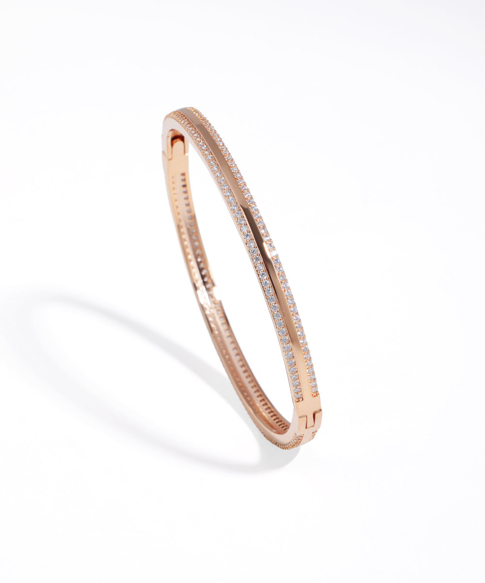 Rose gold bracelet with small diamonds on a white background