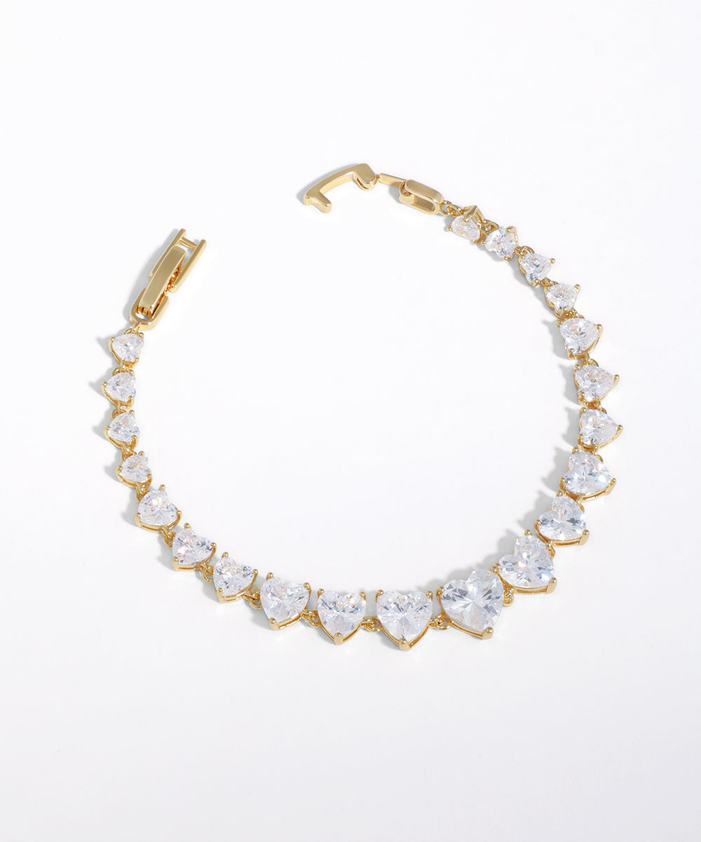 Gold-tone bracelet with graduated heart-shaped clear stones
