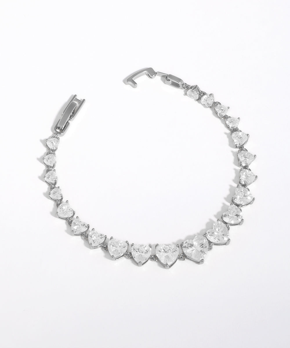 Silver bracelet with heart-shaped crystals on a white background