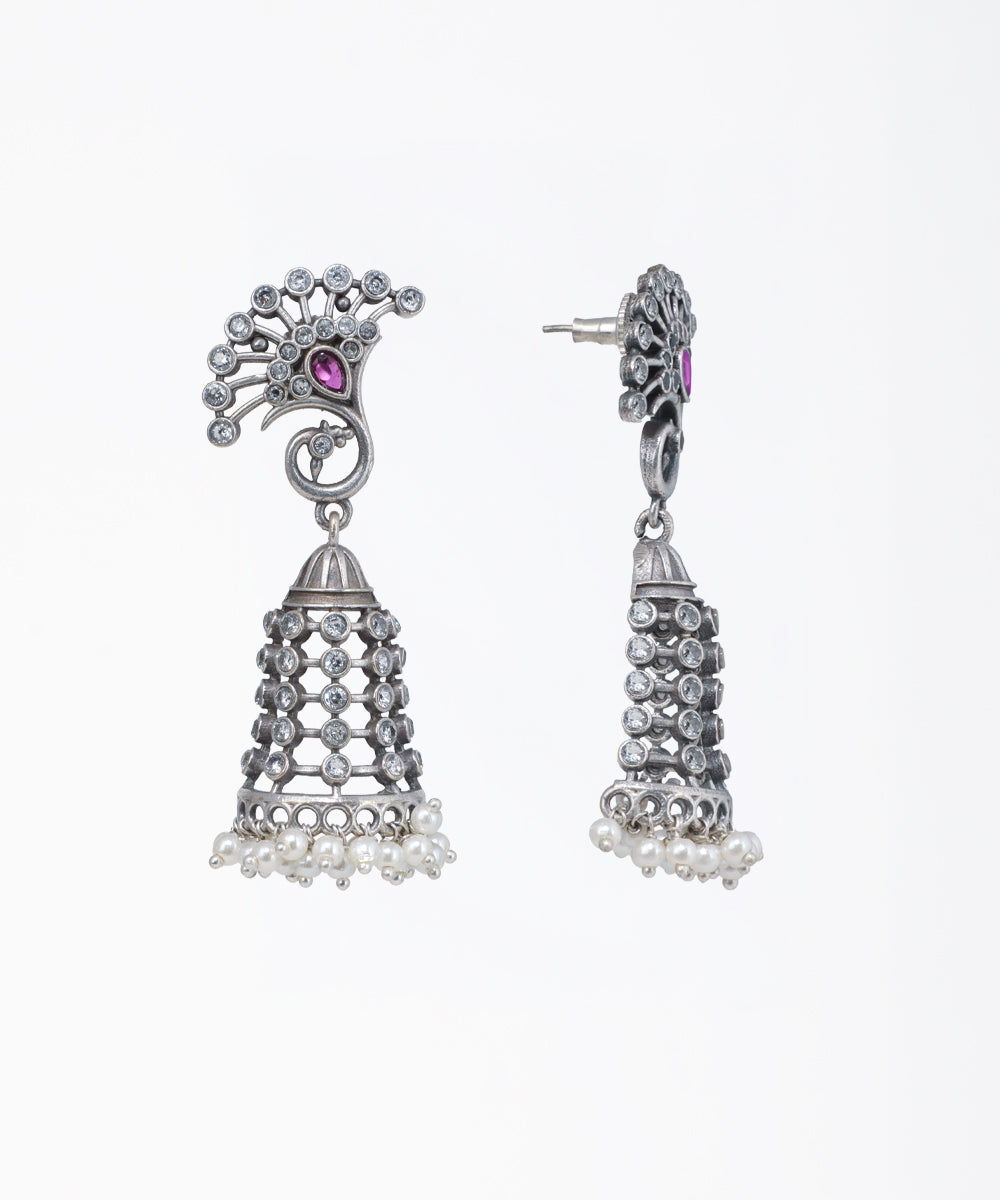 Pair of silver earrings with intricate designs on a white background