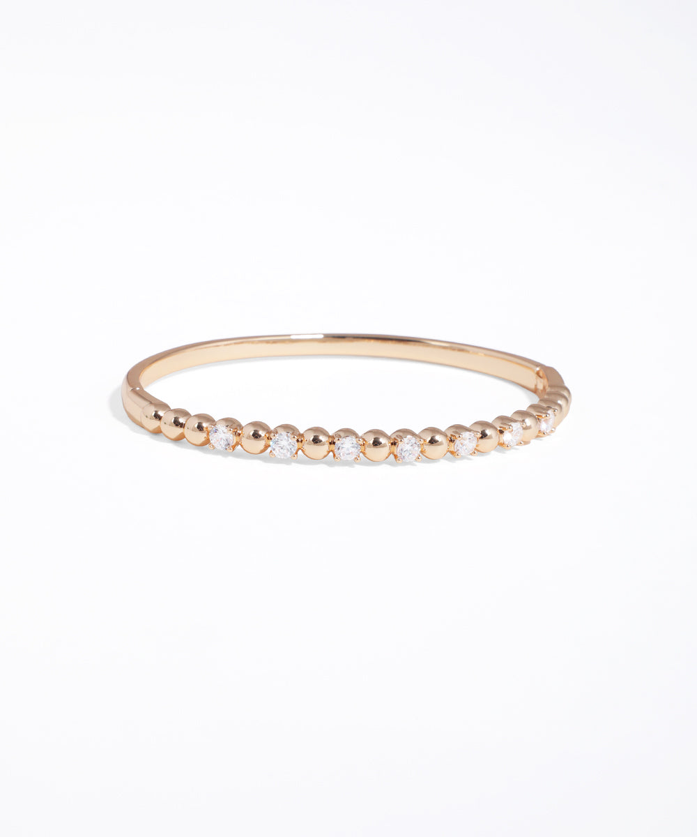 Gold bracelet with small beads on a white background