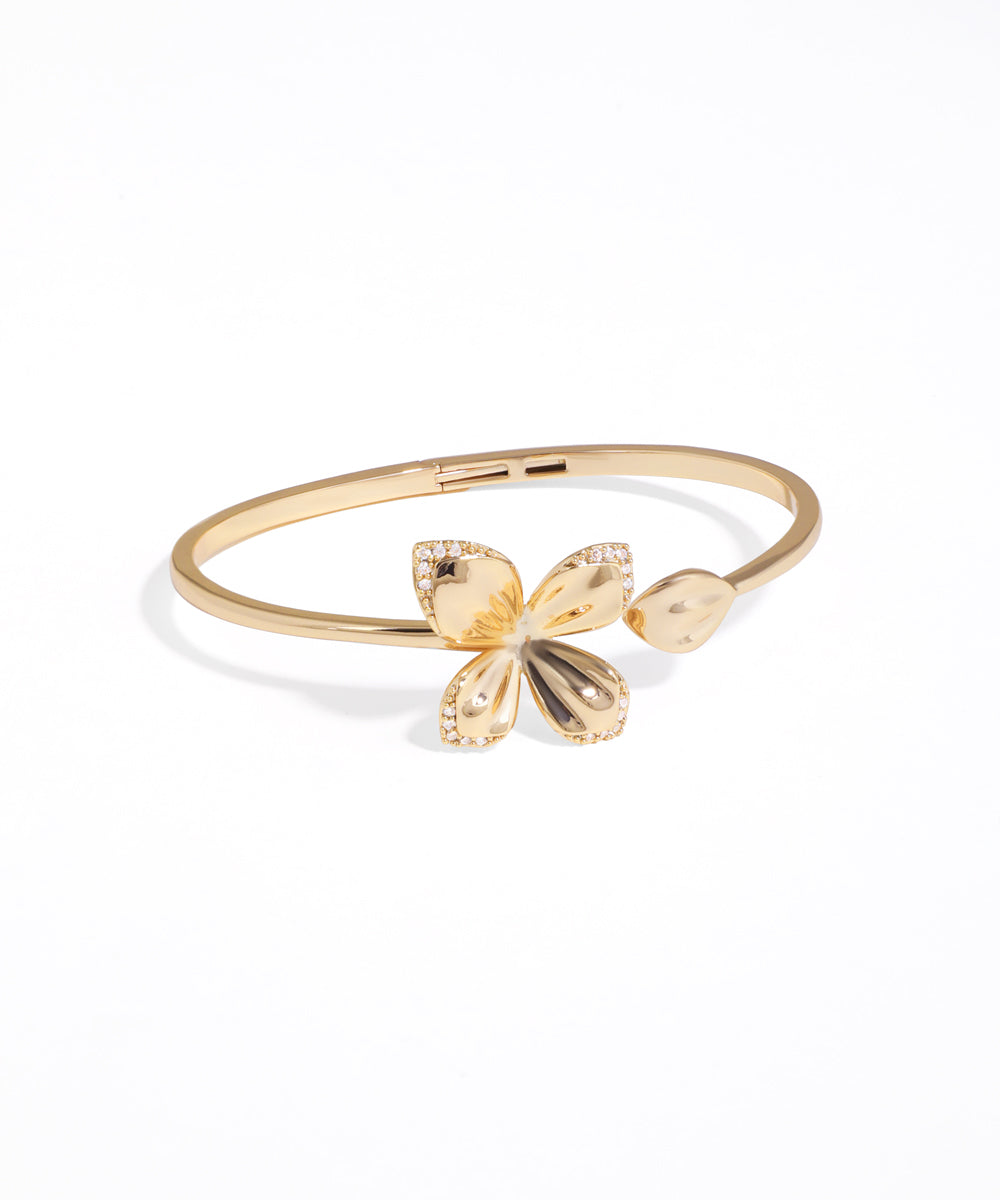 Gold bracelet with butterfly charms on a white background