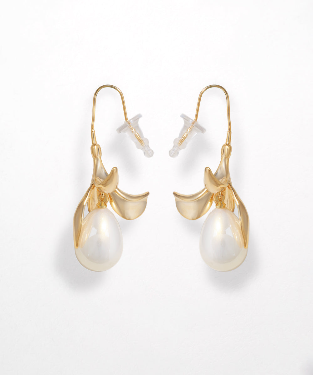 Gold earrings with pearl drops on a white background