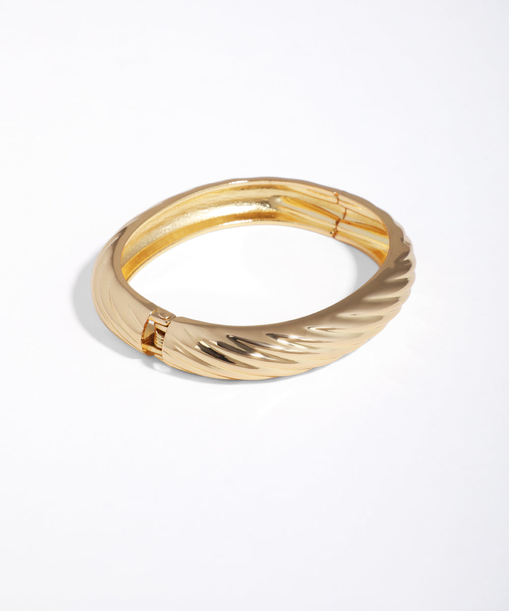 Gold-tone bracelet with a chunky, sculpted twist texture and hinge clasp
