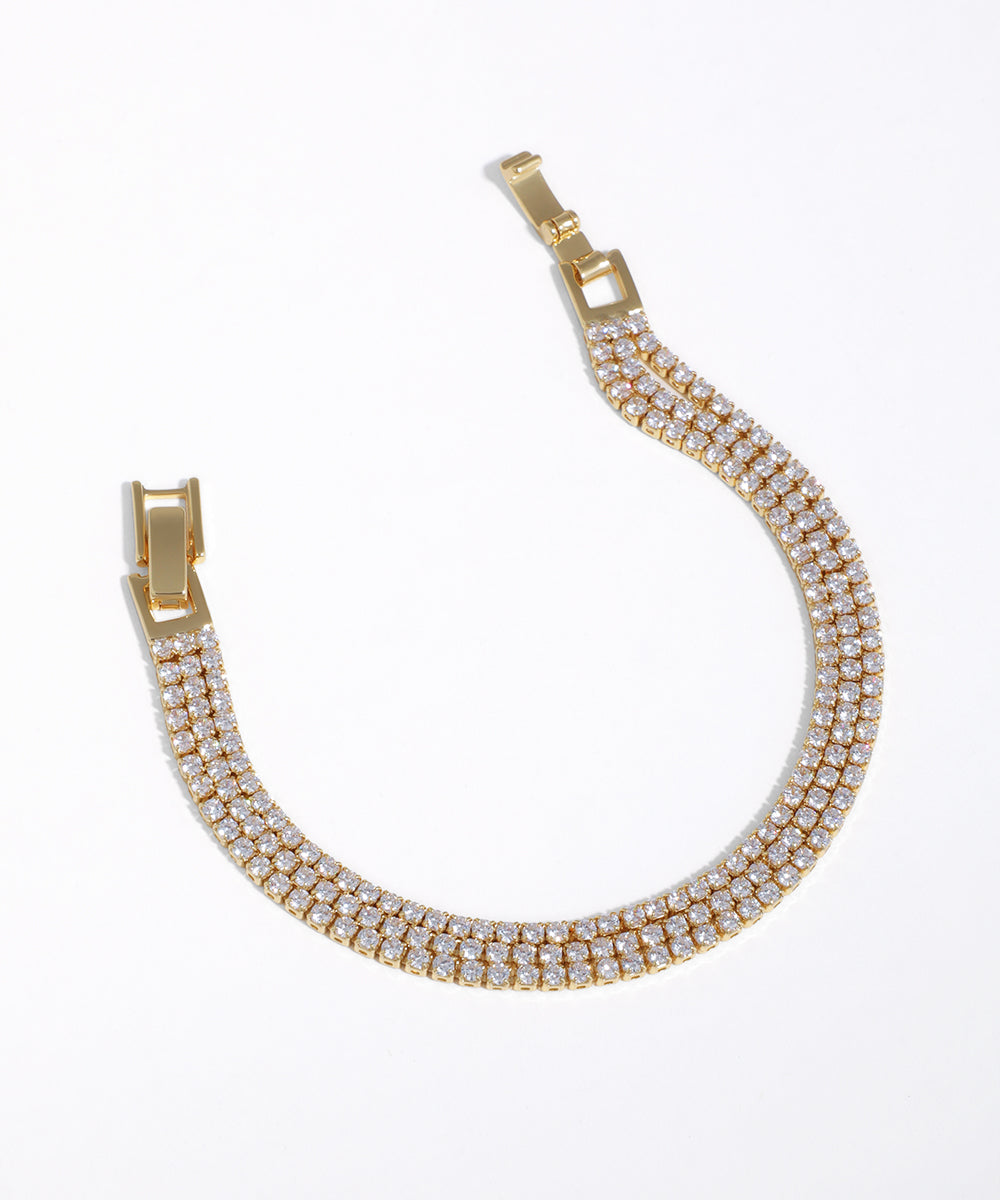 Gold-tone triple row bracelet with continuous clear CZ stones and secure box clasp.