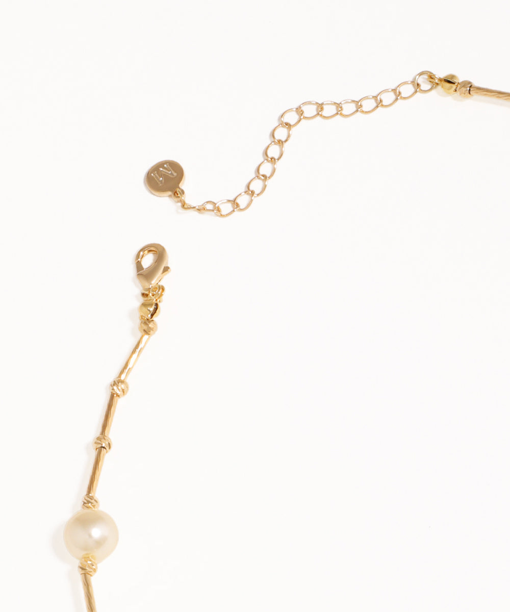 Gold bracelet with a pearl on a white background