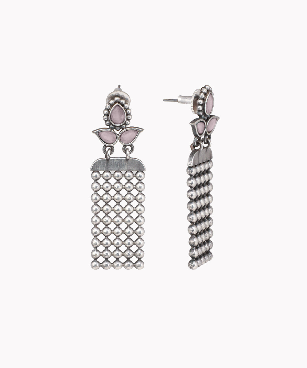 Pair of silver tassel earrings with pink stones on a white background