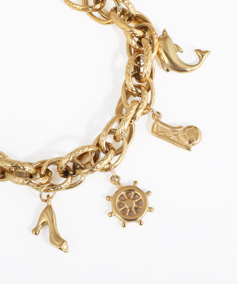 Gold charm bracelet with various charms on a white background
