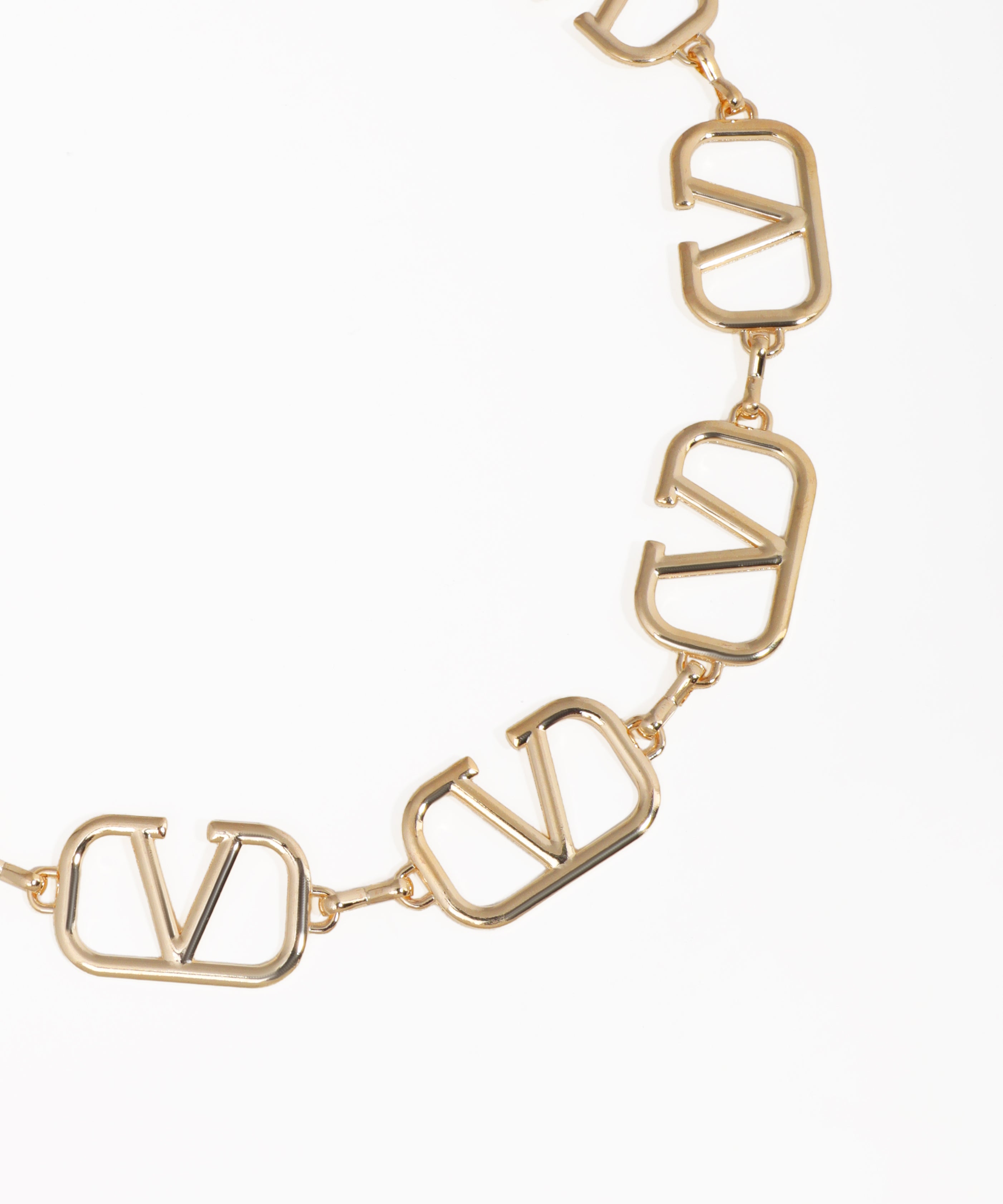 Gold necklace with 'V' shaped links on a white background