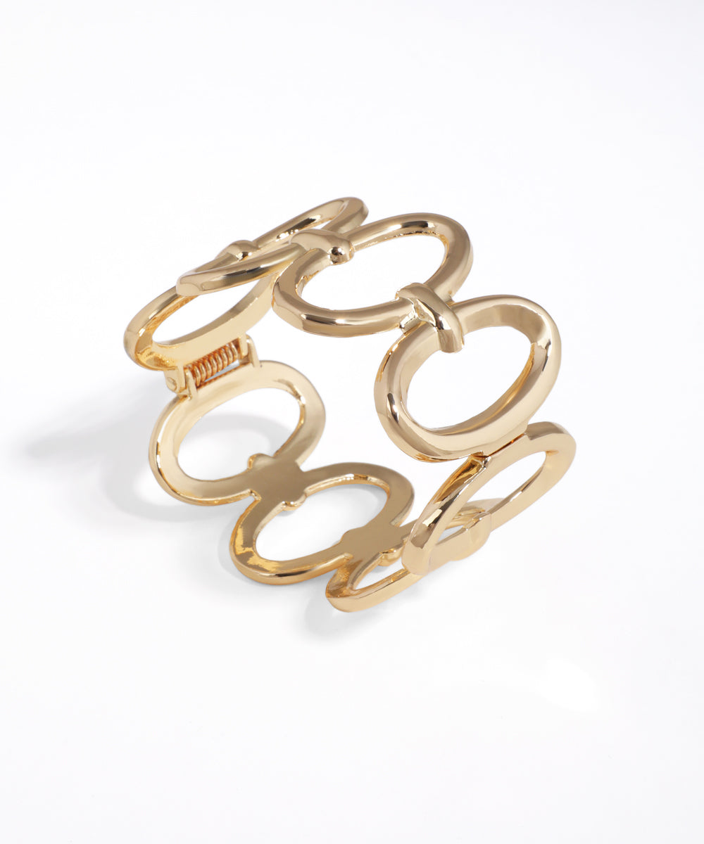 Gold-tone bangle bracelet with bold interlocking oval links and a polished finish.