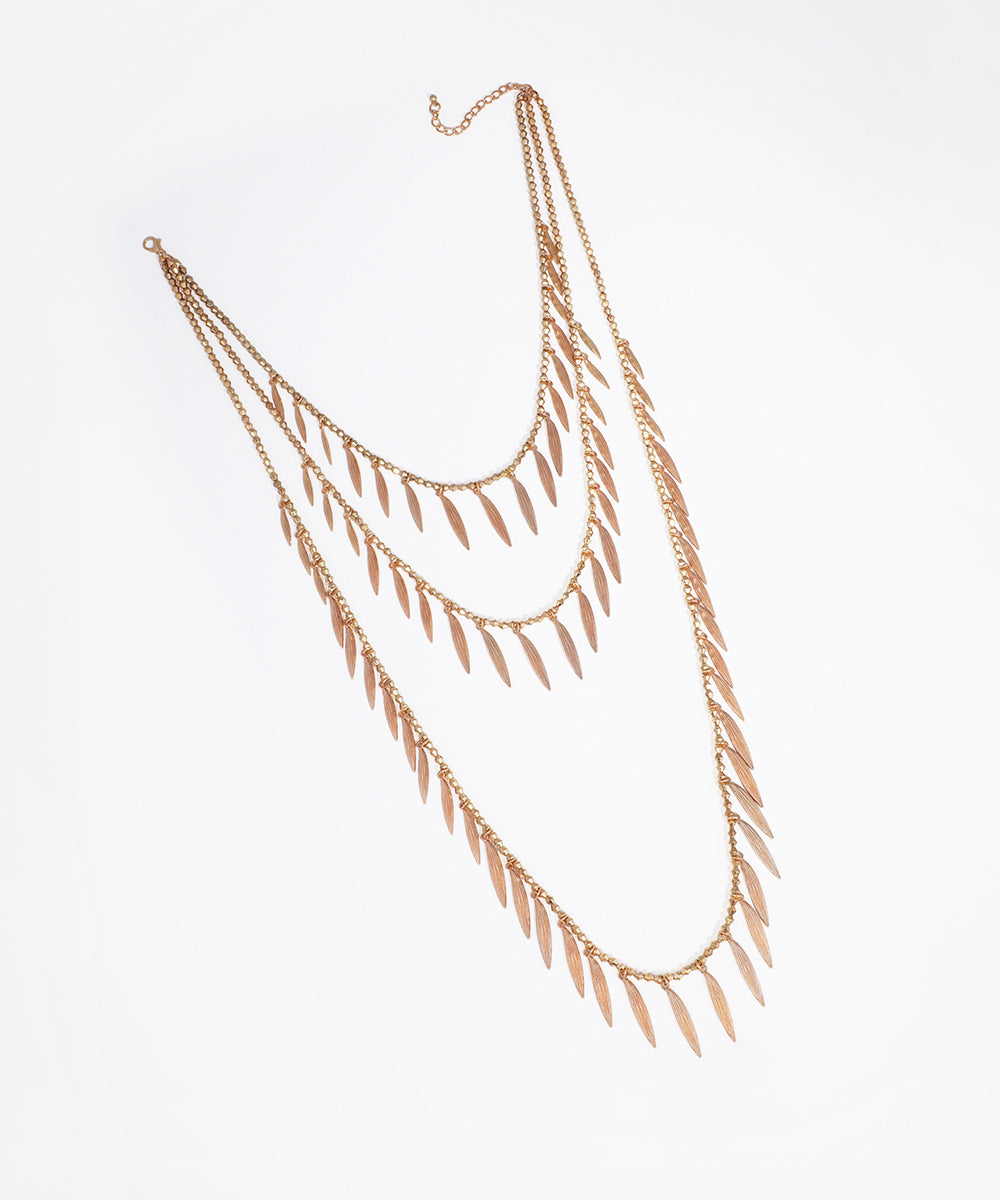 Gold-tone layered necklace with cascading leaf charms and extender chain.