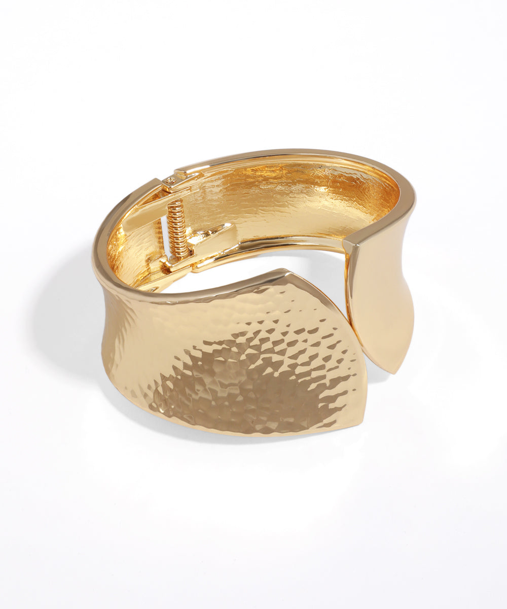 Gold cuff bracelet on a white background