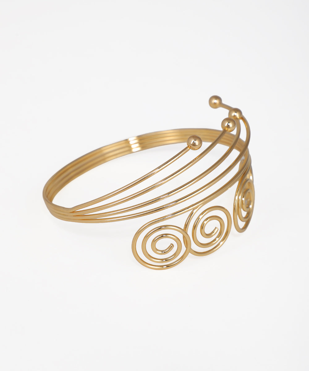 Gold bracelet with spiral design on a white background