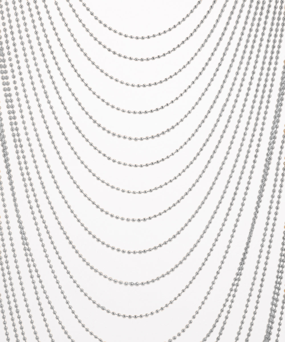 Multiple strands of silver beads on a white background