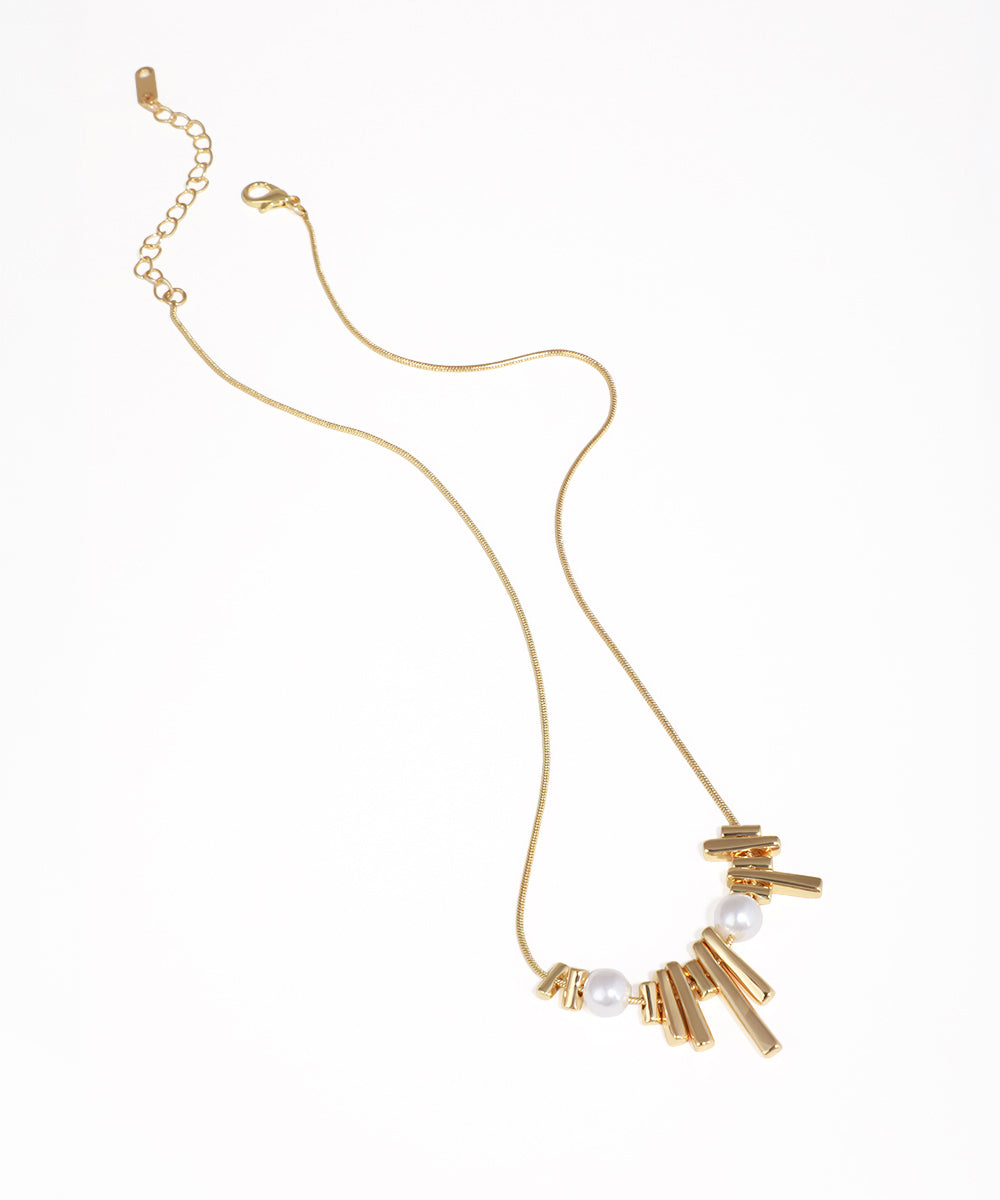 Gold-tone necklace with asymmetrical bar design and faux pearls