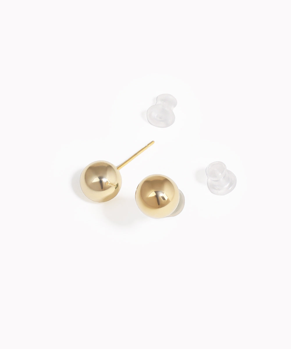 Gold ball earrings on a white background