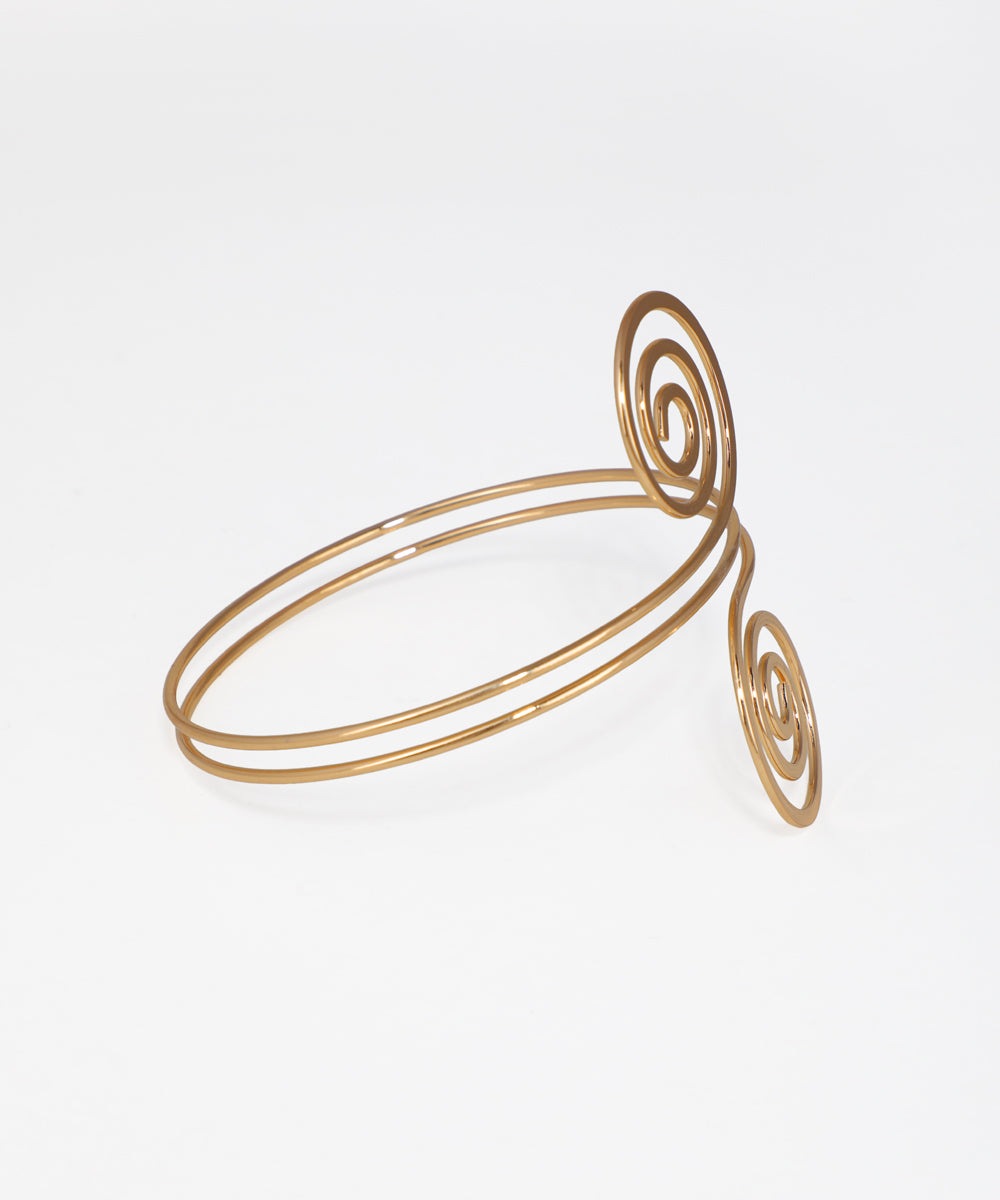 Gold spiral bracelet on a light gray background