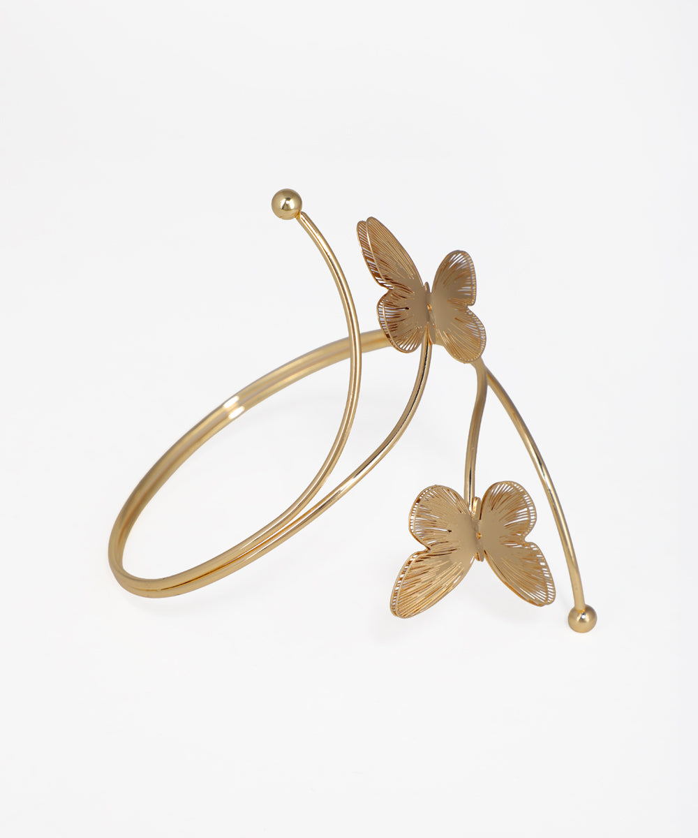 Gold bracelet with butterfly designs on a white background