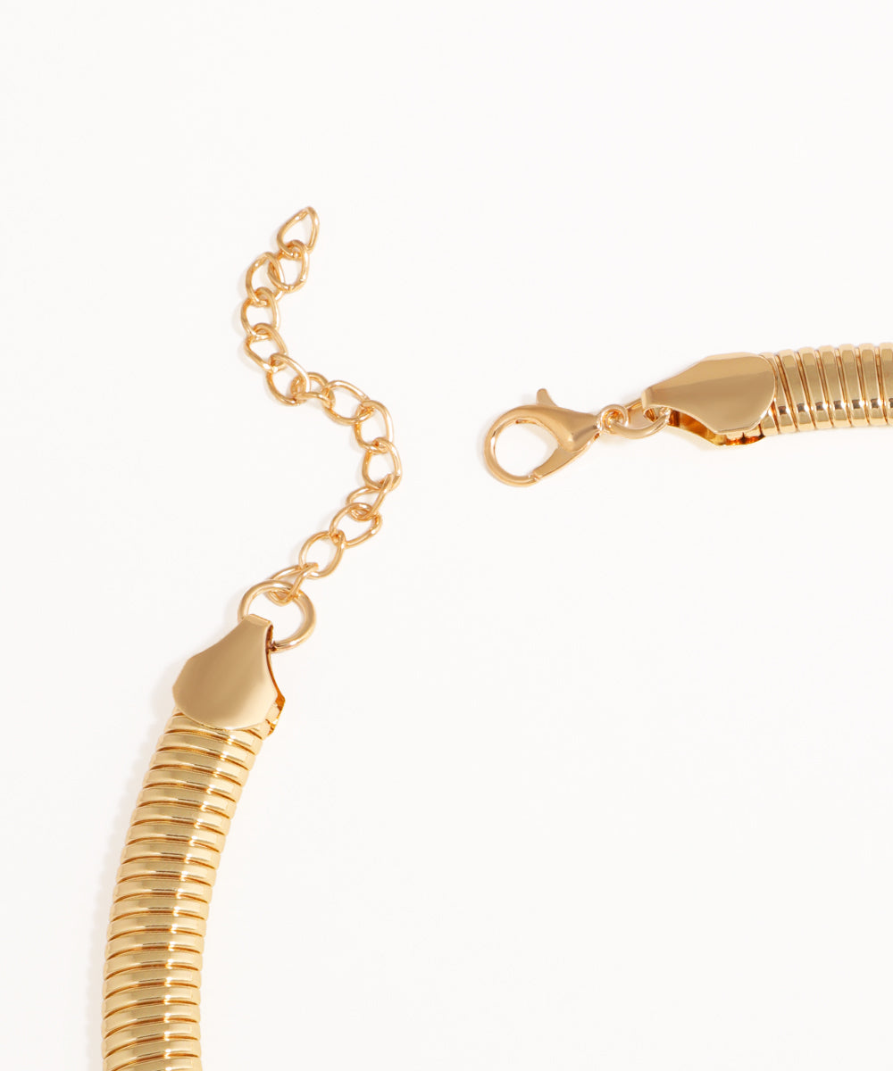 Gold snake chain bracelet on a white background
