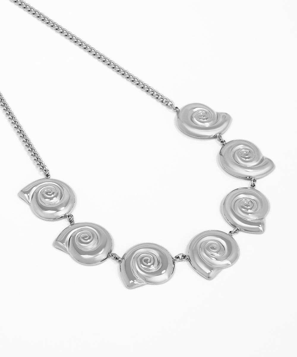 Silver necklace with spiral design on a white background