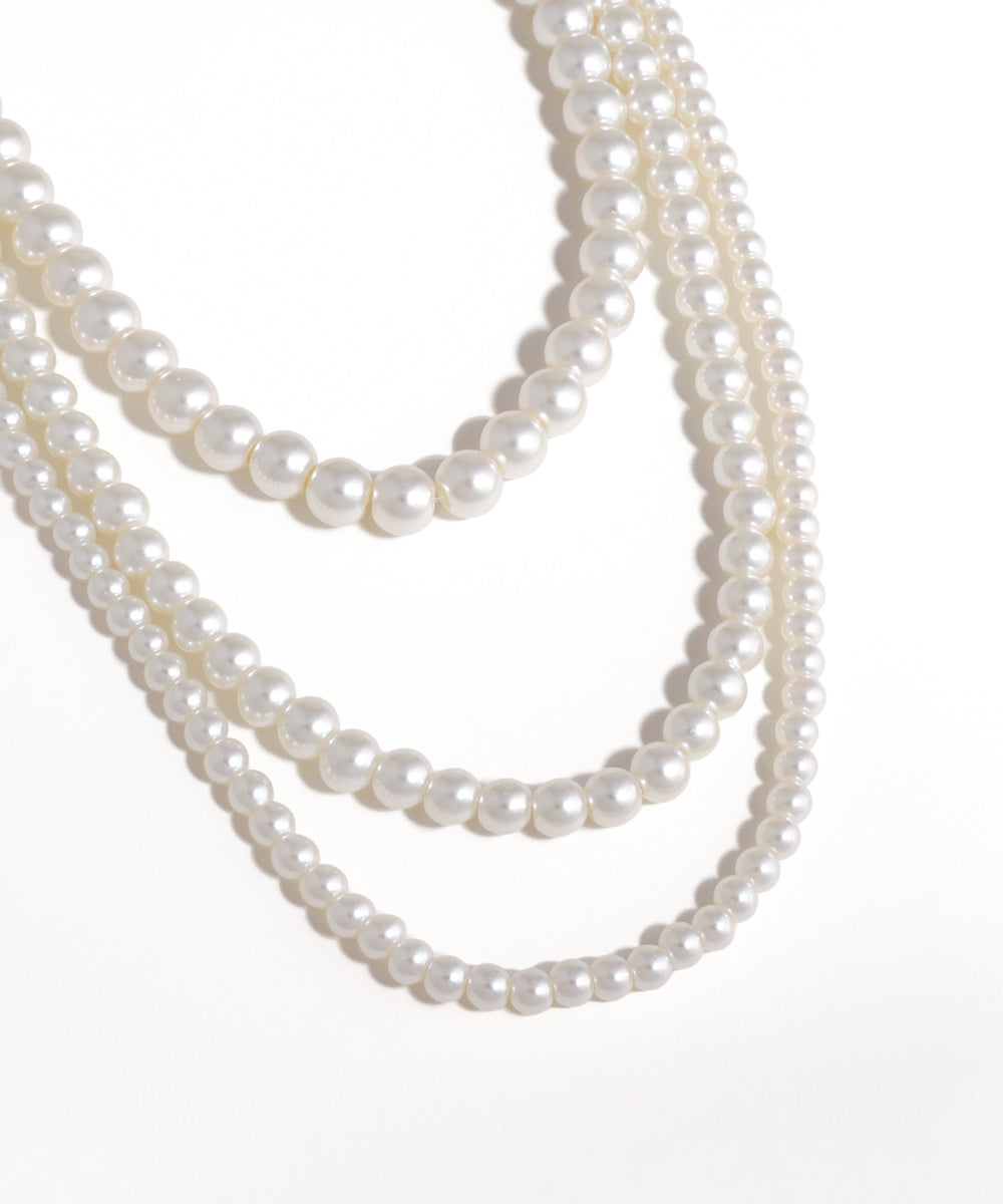 Two strands of pearls on a white background