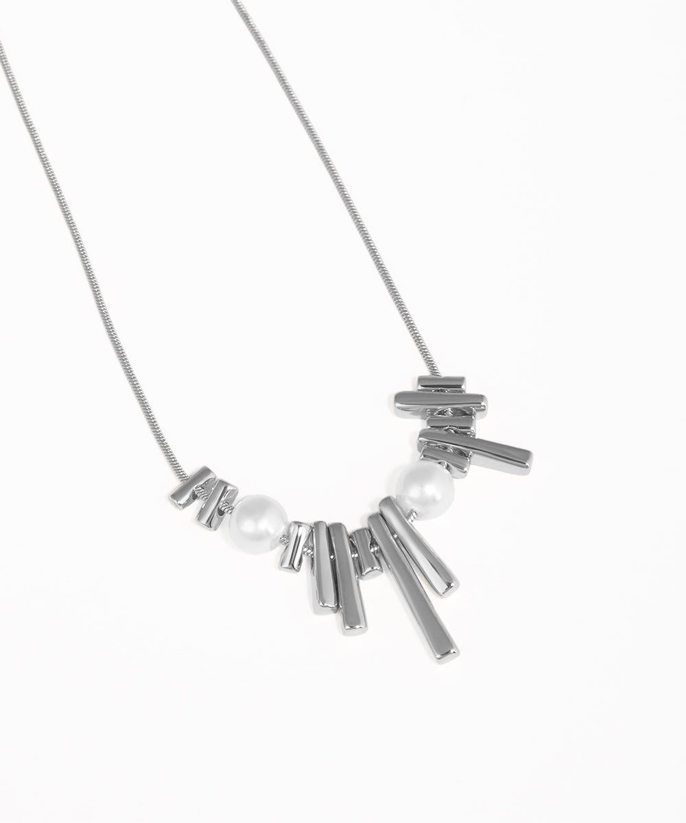 Necklace with metallic bars and pearls on a white background