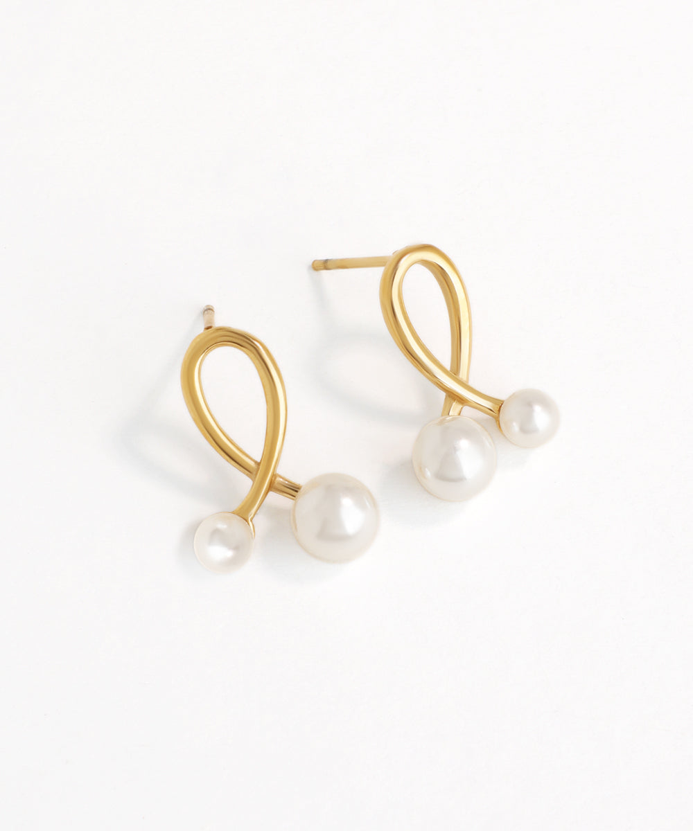 Gold earrings with pearls on a white background