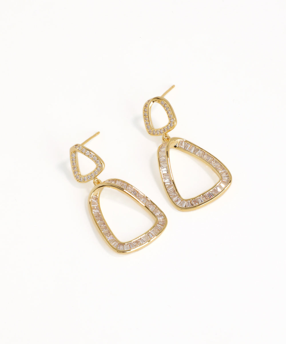Gold hoop earrings with clear gemstones on a white background