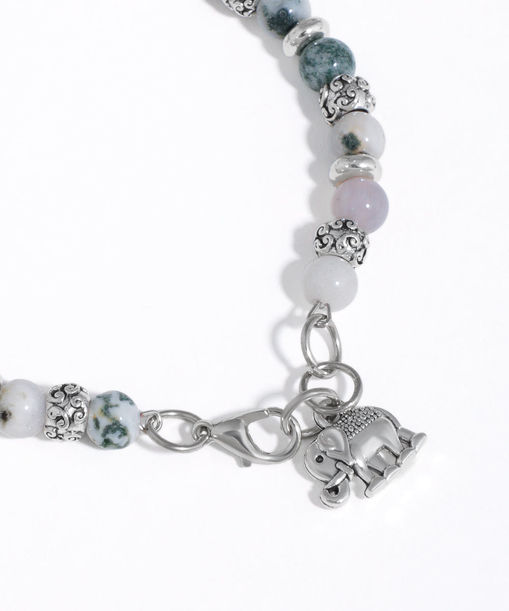 Bracelet with beads and an elephant charm on a white background