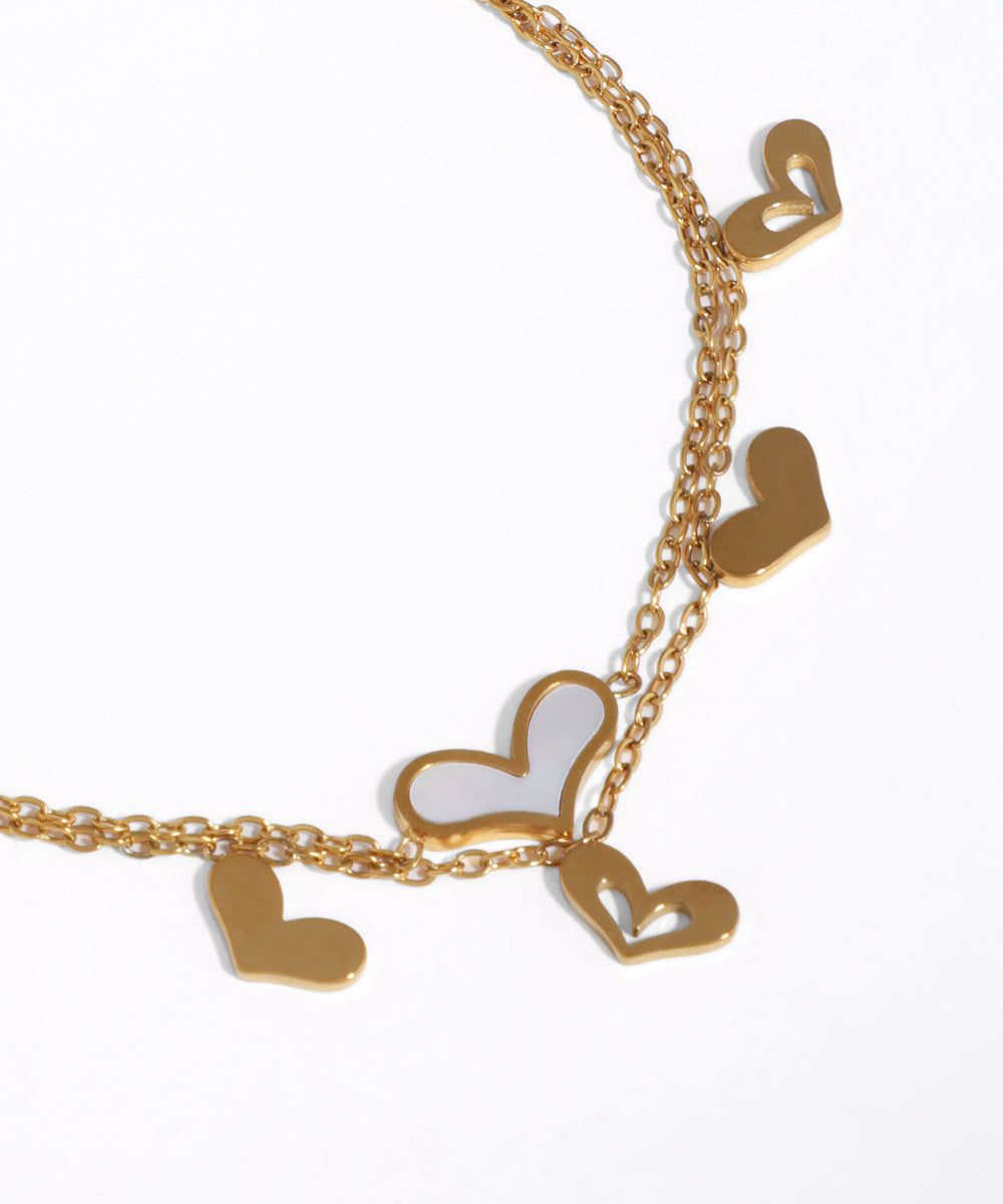 Gold necklace with heart-shaped pendants on a white background