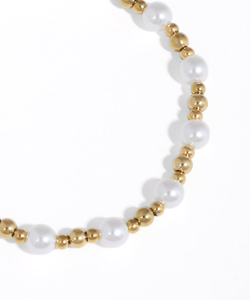 Pearl and gold bead bracelet on a white background