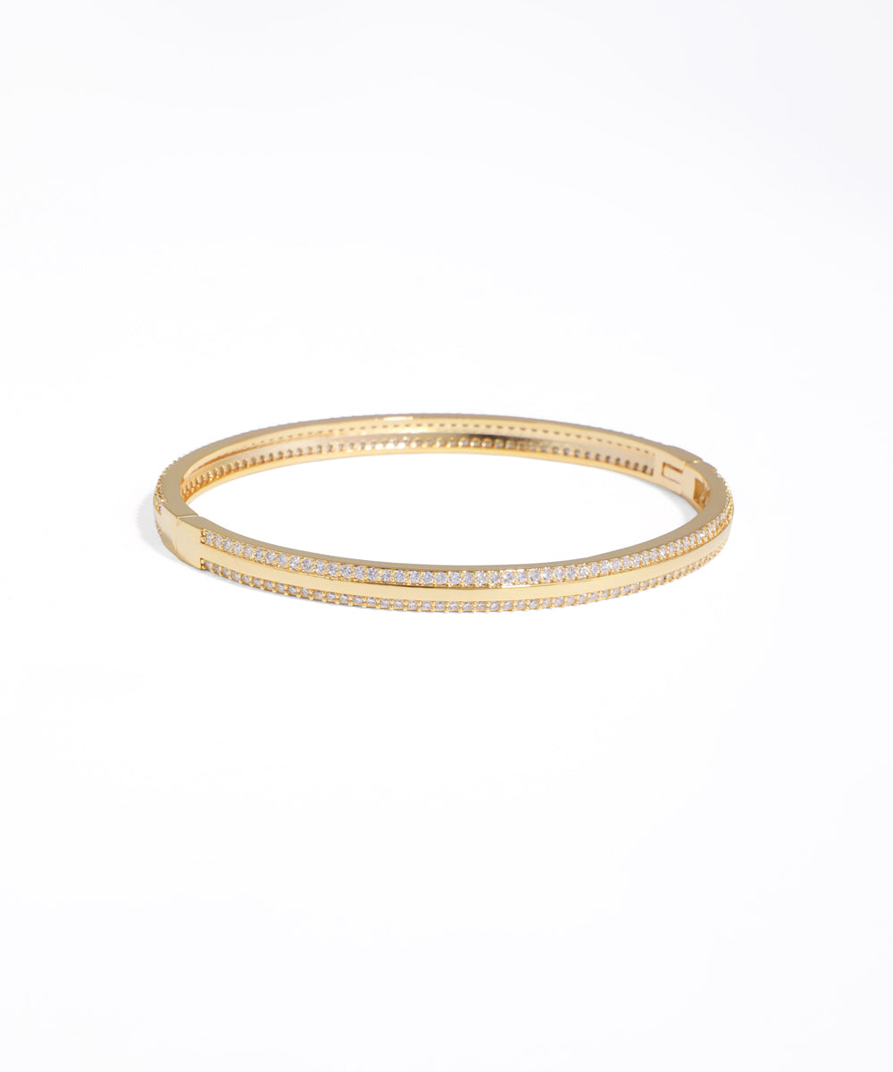 Gold bracelet with embedded stones on a white background