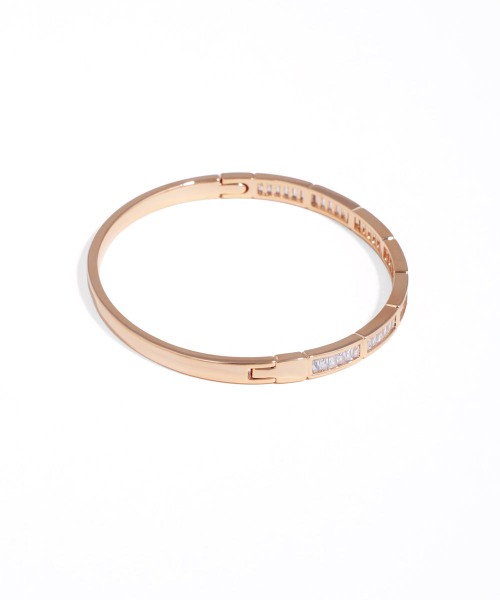 Rose gold bracelet with embedded stones on a white background