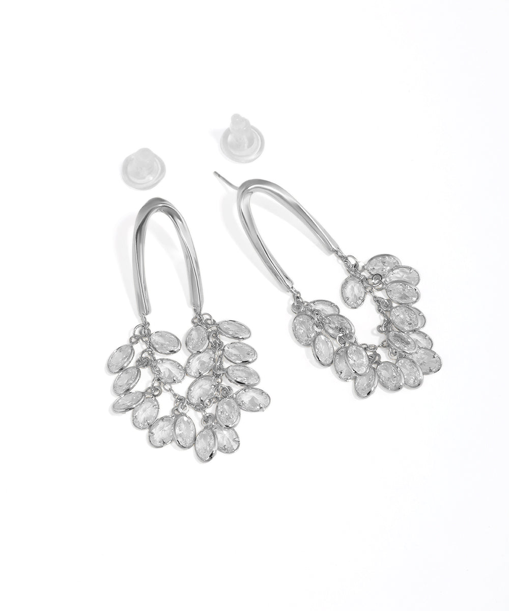 Silver earrings with clear stones on a white background