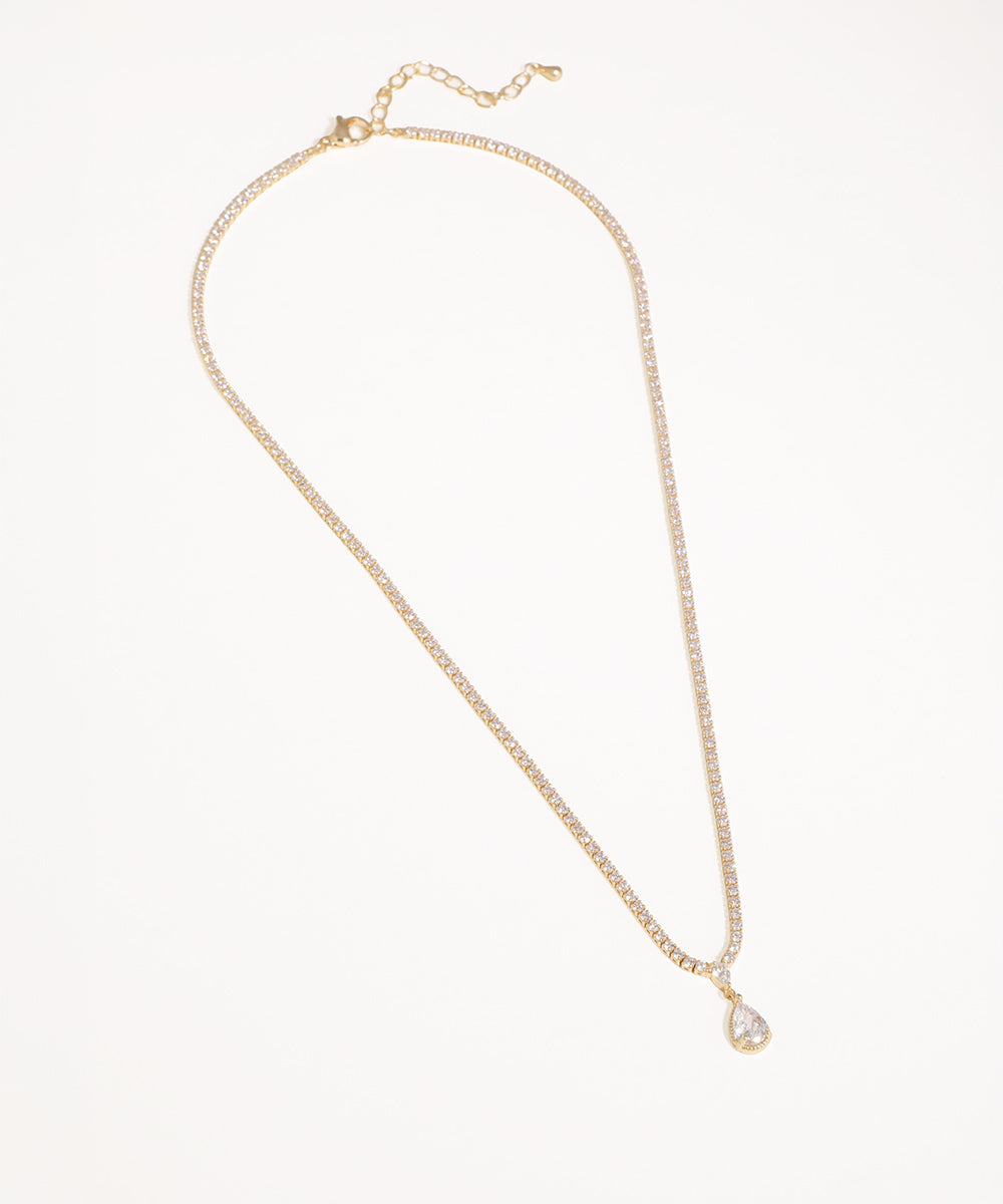 Gold-tone necklace with continuous clear stones and a teardrop CZ pendant