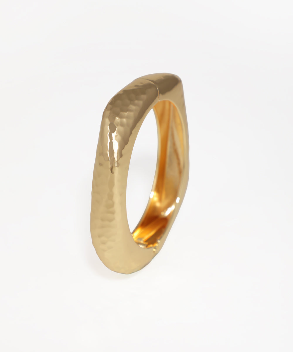 Gold ring with a textured surface on a white background