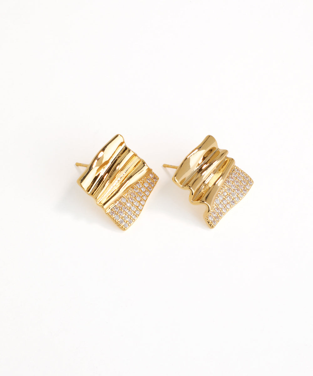 Gold earrings with a textured design on a white background
