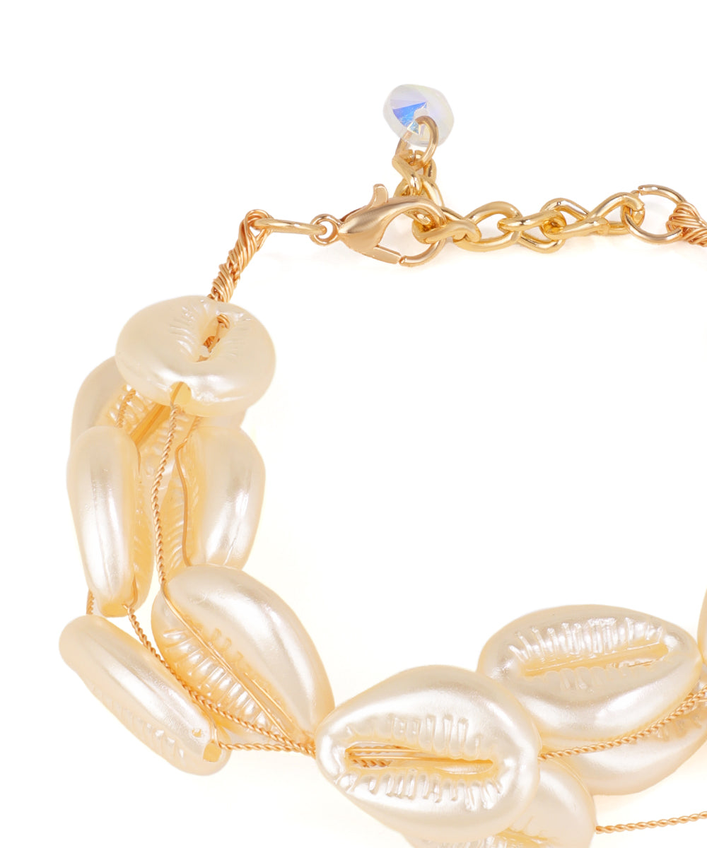 Gold and pearl bracelet on a white background